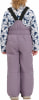 Rückansicht eines Mädchens in Latzhose und gemusterter Jacke.