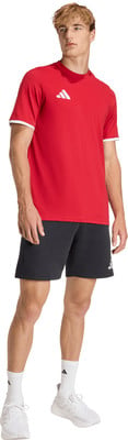 Ein Mann in einem roten Adidas-Shirt und schwarzen Shorts steht. Ein Mann in einem roten Adidas-Shirt und schwarzen Shorts steht.