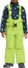 Junge in Winterkleidung mit blauem Fleece-Pullover und grüner Latzhose.