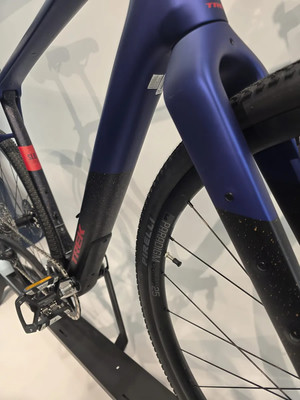 Ein Teil eines dunkelblauen Trek-Fahrrads mit Pirelli-Aufschrift auf dem Reifen. Ein Teil eines dunkelblauen Trek-Fahrrads mit Pirelli-Aufschrift auf dem Reifen.