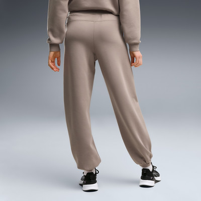 Rückansicht einer Person in braunen Jogginghosen und schwarzen Turnschuhen. Rückansicht einer Person in braunen Jogginghosen und schwarzen Turnschuhen.