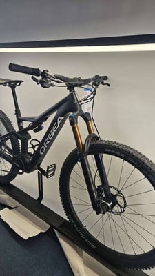 Schwarzes Orbea Mountainbike auf einem Ständer mit Fox-Dämpfern. Schwarzes Orbea Mountainbike auf einem Ständer mit Fox-Dämpfern.