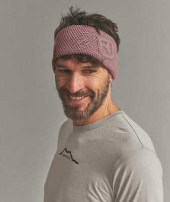 Mann mit rosafarbenem Stirnband und T-Shirt mit Berglogo.