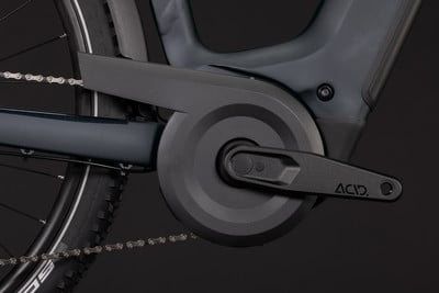 Detailaufnahme von Kurbeln und Kette eines E-Bikes vor dunklem Hintergrund. Detailaufnahme von Kurbeln und Kette eines E-Bikes vor dunklem Hintergrund.