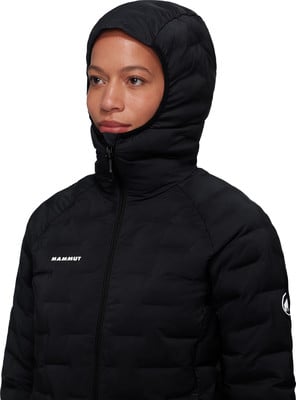 Eine Frau in einer schwarzen Daunenjacke mit Kapuze und Mammut-Logo.