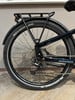 Hinterrad eines dunkelblauen E-Bikes mit Gepäckträger und Schutzblech.