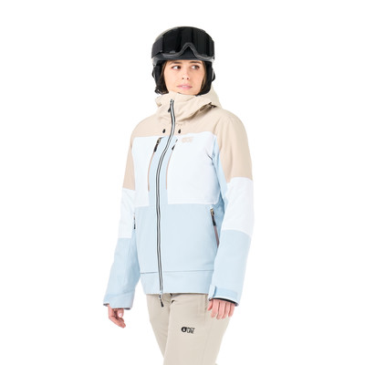 Eine Frau in einer Skijacke und einem Helm vor weißem Hintergrund. Eine Frau in einer Skijacke und einem Helm vor weißem Hintergrund.