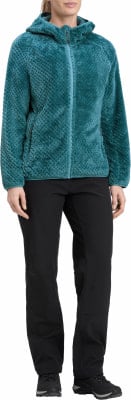 Eine Frau in einem tealfarbenen Fleece-Kapuzenpullover und schwarzer Hose. Eine Frau in einem tealfarbenen Fleece-Kapuzenpullover und schwarzer Hose.