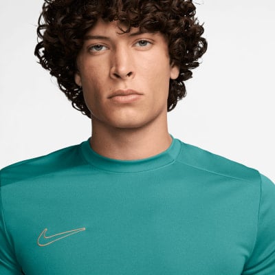 Férfi teal pólóban, narancssárga Nike logóval a mellkasán. Férfi teal pólóban, narancssárga Nike logóval a mellkasán.