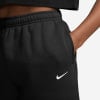 Černé tepláky Nike s bílým logem a kapsou.