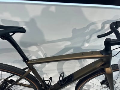Ein goldenes Fahrrad mit schwarzem Sattel und Lenker vor weißem Hintergrund. Ein goldenes Fahrrad mit schwarzem Sattel und Lenker vor weißem Hintergrund.