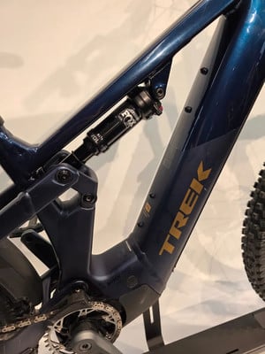 Detail des Rahmens eines dunkelblauen E-Bikes mit Fox-Dämpfer.