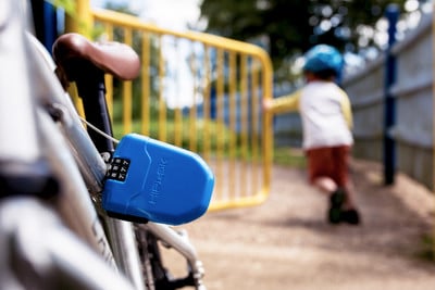 Ein blaues Fahrradschloss mit Zahlencode ist am Fahrradrahmen befestigt.