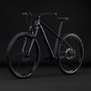 Schwarzes Mountainbike mit Federung und Scheibenbremsen vor dunklem Hintergrund.