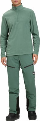 Ein Mann in einem grünen Fleece-Pullover und Hose mit schwarzen Details. Ein Mann in einem grünen Fleece-Pullover und Hose mit schwarzen Details.