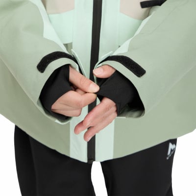 Detail der Hände in schwarzen Manschetten und einer hellgrünen Jacke mit Klettverschlüssen. Detail der Hände in schwarzen Manschetten und einer hellgrünen Jacke mit Klettverschlüssen.