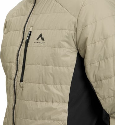 Detail einer McKinley-Daunenjacke mit Logo und Reißverschluss auf beigem Hintergrund. Detail einer McKinley-Daunenjacke mit Logo und Reißverschluss auf beigem Hintergrund.