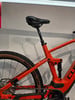 Orange Mountainbike mit schwarzem Sattel und Federung im Detail.