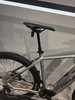 Detail eines E-Mountainbikes mit sichtbarem Antrieb, Sattel und Hinterrad.