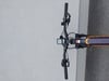 Lenker eines E-Bikes mit Display und Bedienelementen auf grauem Hintergrund.