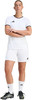Eine Frau in einem Fußballtrikot und Shorts mit verschränkten Armen.