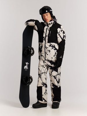 Ein Mann in Skibekleidung steht mit einem Snowboard, das auf seiner Schulter lehnt. Ein Mann in Skibekleidung steht mit einem Snowboard, das auf seiner Schulter lehnt.