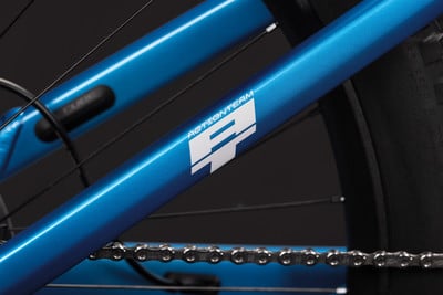 Blauer Fahrradrahmen mit ACTIONTEAM-Logo und Kette. Blauer Fahrradrahmen mit ACTIONTEAM-Logo und Kette.