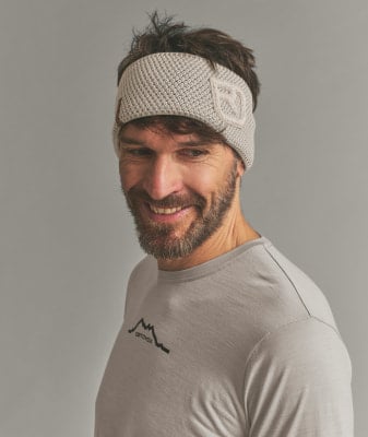 Ein Mann mit einem Stirnband und einem T-Shirt mit Bergmotiv.