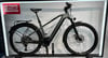 Graues Cube E-Bike mit Gepäckträger und Schutzblechen im Geschäft.