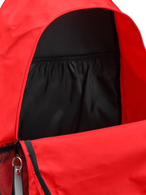 Detail eines offenen roten Rucksacks mit schwarzem Innenfutter und Tasche. Detail eines offenen roten Rucksacks mit schwarzem Innenfutter und Tasche.