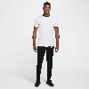 Mann in weißem T-Shirt und schwarzer Hose mit Nike-Logo.