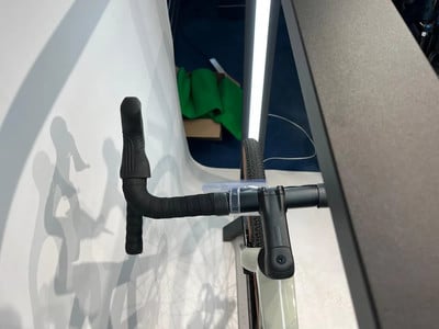 Ein Teil des Fahrradlenkers mit schwarzem Lenkerband und silbernem Vorbau. Ein Teil des Fahrradlenkers mit schwarzem Lenkerband und silbernem Vorbau.