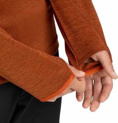 Detail eines orangefarbenen Hemdes mit Daumenlöchern und Kontrastsaum.
