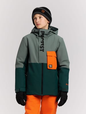 Ein Junge in einer Winterjacke und orangefarbener Hose mit Mütze. Ein Junge in einer Winterjacke und orangefarbener Hose mit Mütze.