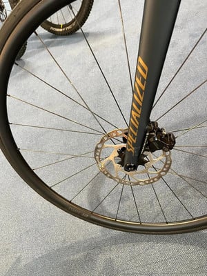 Detail eines Fahrrad-Vorderrads mit Scheibenbremse und Specialized-Logo. Detail eines Fahrrad-Vorderrads mit Scheibenbremse und Specialized-Logo.