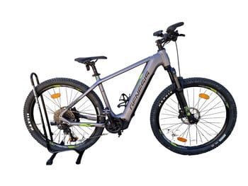 Graues Genesis E-Mountainbike auf Ständer mit Federung und Scheibenbremsen.