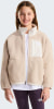 Ein Mädchen in einer beige Fleecejacke mit weißem T-Shirt und lila Hose.
