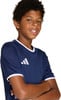 Ein Junge mit lockigem Haar in einem dunkelblauen T-Shirt mit Adidas-Logo.