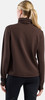 Rückansicht einer Frau in braunem Langarm-Pullover und schwarzer Leggings.