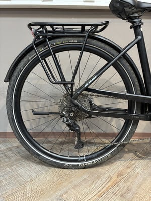Hinterrad eines schwarzen E-Bikes mit Schutzblech und Gepäckträger. Hinterrad eines schwarzen E-Bikes mit Schutzblech und Gepäckträger.