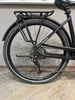Hinterrad eines schwarzen E-Bikes mit Schutzblech und Gepäckträger.