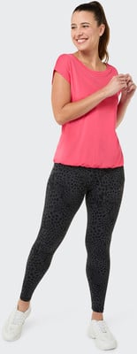 Eine Frau in einem pinken Oberteil und dunklen Leggings mit Leopardenmuster. Eine Frau in einem pinken Oberteil und dunklen Leggings mit Leopardenmuster.