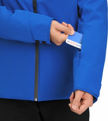 Ein Mann steckt eine Karte in eine Ärmeltasche einer blauen Jacke.