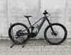 Ein graues Conway E-Bike mit schwarzen Rädern und Federung steht auf Pflastersteinen.