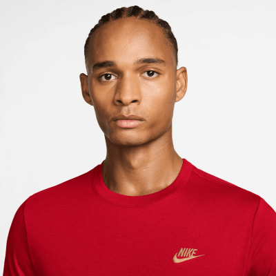 Ein Mann in einem roten Nike-T-Shirt mit Logo auf der Brust.
