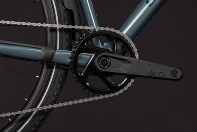Detailaufnahme von Kettenblatt und Kette an einem Fahrrad mit dunkelblauem Rahmen. Detailaufnahme von Kettenblatt und Kette an einem Fahrrad mit dunkelblauem Rahmen.
