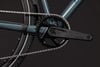 Detailaufnahme von Kettenblatt und Kette an einem Fahrrad mit dunkelblauem Rahmen.