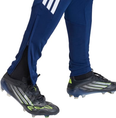 Blaue Adidas Fußballhosen mit weißen Streifen und schwarzen Fußballschuhen.