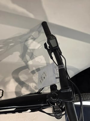 Detail des Lenkers mit Display und Schatten des Fahrrads an der Wand. Detail des Lenkers mit Display und Schatten des Fahrrads an der Wand.