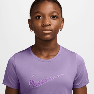 Mädchen in lila T-Shirt mit Nike-Logo auf der Brust. Mädchen in lila T-Shirt mit Nike-Logo auf der Brust.